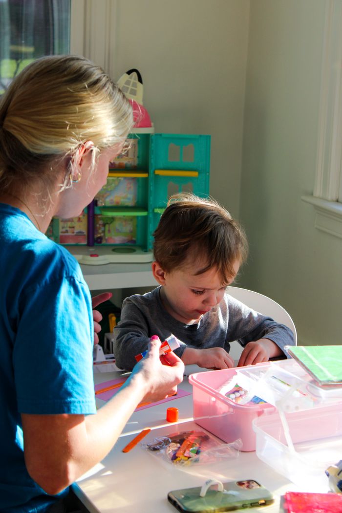 A young child involved in an arts and crafts session, fostering creativity and learning indoors.